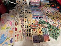 Photo showing multiple vintage sticker sets new in packaging, arranged overlapped with visible animal, Halloween, floral, and cartoon designs.