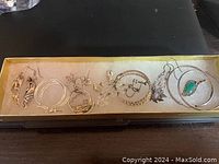 Photo showing an overhead view of all the sterling silver earrings in a yellow box with white padding, displaying various styles including hoops and dangles.