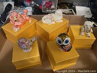 Five animal-shaped rhinestone trinket figures on yellow boxes including a dog, cat, bird, owl, and second dog
