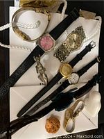 Overview of six watches with various strap styles and three small animal figures on a white surface.