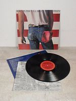 Vinyl LP with record, album cover, lyric sheet and inner sleeve laid out on white surface