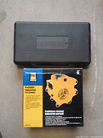 Photo showing black hard case with LazerPro brand and Power Fist Portable Industrial Fan Blower box with product image and specs.