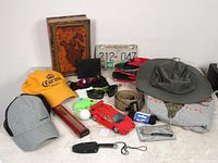 Overview of the lot showing all items: hats, sunglasses, tools, toy truck, secret book, and belt