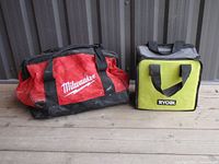 Photo showing both Milwaukee large red tool bag and smaller green Ryobi tool bag side by side on a wooden floor against a gray wall.