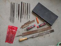 Woodworking files in various shapes and handles, black rectangular block, two file handles and red pouch with small files