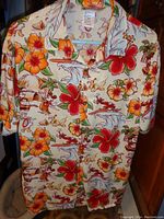 Full shirt front view showing vibrant tropical hibiscus and Disney character print