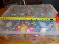 Closed decorative plastic storage box with ruler showing approximate 13-inch length