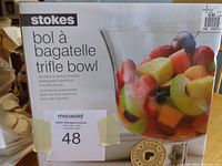 Photo showing the front of the box with the Stokes branding and product name in English and French, including an image of the bowl filled with cut fruit.