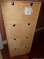Front view of wooden storage cabinet showing 8 drawers with finger cut-out handles and a MaxSold auction label attached.