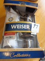 Front view of unopened Weiser SmartKey door lock package showing product in clear plastic blister with branding and 'Collections' label.