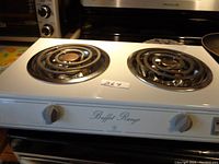 Top view of the white double burner buffet range showing two coil heating elements and front knobs.