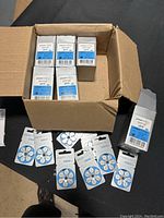Open box with multiple packages of PowerOne P675 hearing aid batteries fanned out.