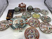 Photo showing entire lot on white surface including plates and porcelain pieces