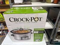 New sealed Crock-Pot original slow cooker box with product image and logo visible on front shelf.