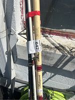 Close-up of Shakespeare branded beige fishing rod with red accents, showing condition and label.