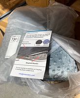 Blanket packaged inside plastic bag with informational tag about removable cover on top