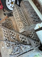 Stack of individual lattice panels and connected cresting segments on wood floor