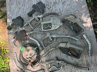 Top view showing assorted early gas pump nozzles laid out on a wooden surface, highlighting diversity in nozzle design and condition.