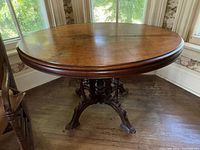 Front view of oval table showing tabletop and carved pedestal base