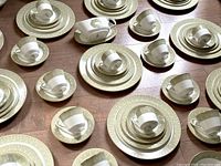 Scattered arrangement of stacked plates and cups showing pattern detail