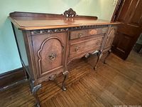 Front-left perspective showing carved backsplash, apron detail and cabriole legs