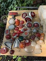 Overview photo showing the full assortment of various lights, reflectors, and lenses on a wooden table outdoors.