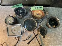 Seven vintage automobile dashboard clocks including 1959 Cadillac, 1941 Buick, and other models.