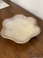 Top-down view of the vintage cream flower-shaped bowl with gold rim showing the petal design and glaze pattern.