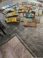 Top-down photo of a large assortment of books and magazines spread on carpet including National Geographic and Reader's Digest.
