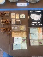 Top-down view of the entire lot showing wooden figures, lighters, tickets, the quarter collection binder, Donald Duck ring, and Stanley Cup coin.