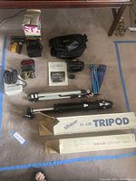 Overview of tripods, camera bags, and accessories on carpet