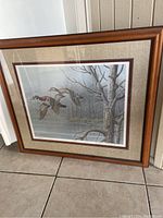 Framed duck print by Richert showing entire artwork with wood frame and textured matting.