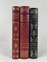 Three Franklin Library books standing upright: John Donne Poems, Rudyard Kipling Stories, and Pere Goriot, showing their leather-bound spines with gold embossing.