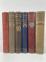 Front view of six hardcover books showing spine titles and colors.