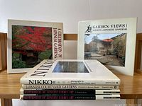 Photo of six hardcover Japanese garden books arranged upright and stacked, showing front covers and spines with titles.