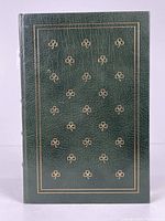 Front cover of the book showing dark green leather with gilded shamrock/clover motifs and border lines.