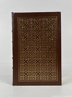 Front cover showing brown full leather binding with gold embossed intricate pattern design
