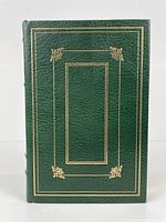 Front cover of the book showing green full leather with gold gilt decorative borders and corner flourishes.