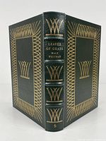 Front and back cover in green leather with gold embossing and decorative design.