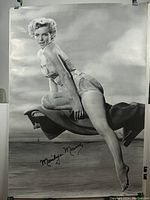 Full body black and white Marilyn Monroe poster showing sitting pose with printed signature.