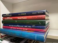 Stack of six hardcover books showing spines with titles related to British military medals and artillery history.