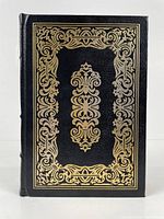 Front cover of the book with black leather and gold gilt ornate design.