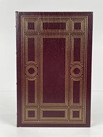 Front cover of the burgundy leather bound book with gold geometric embossing.