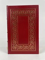Front cover of the red leather bound book with gold embossed border