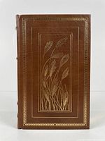 Front cover of full leather bound book showing embossed gold wheat design.