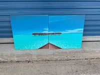 Two square art panels placed side by side showing tropical beach and overwater bungalows ending in the horizon.
