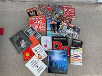 Books and magazines laid out on a concrete floor showing various music and photography themed titles.