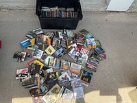 Bin filled with CD cases and loose CDs on floor
