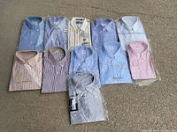 Top view of 10 men's dress shirts laid out on the ground showing variety of colors and patterns