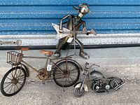 Photo showing musician metal bottle holder holding guitar, vintage-style bicycle, and motorcycle on concrete with metal background